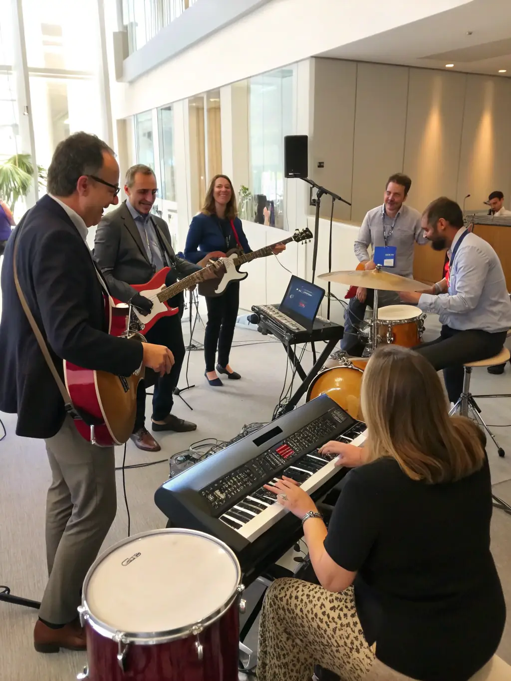 A diverse group of adults learning to play blues instruments (guitar, harmonica) in a workshop setting. The instructor is demonstrating techniques, and participants are practicing.